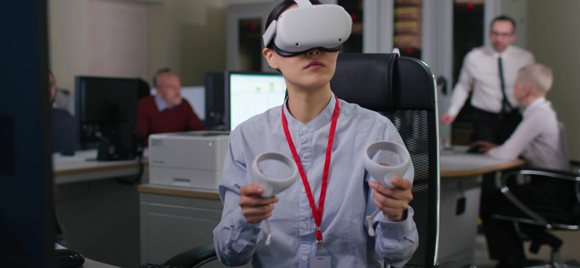 Young woman in formal wear use vr headset and joysticks in modern office